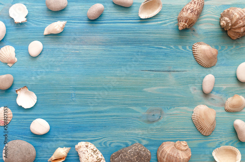 Summer vacation background with copy space. Many seashells and pebbles on blue background mock up.