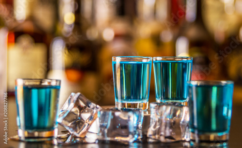 фотографія Popular blue drink shot kamikaze on the background of the bar with bottles, a re