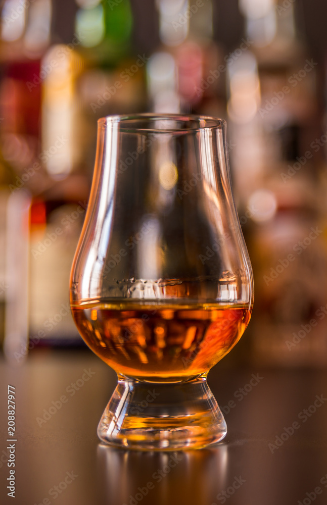 Scottish whisky in a glass with ice cubes, golden color whiskey
