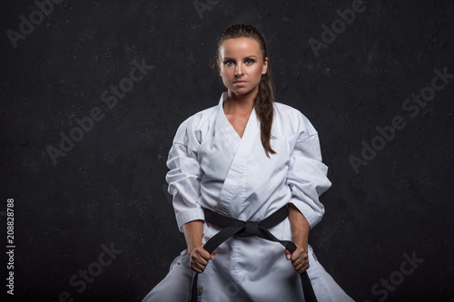  A girl in a white kimono with a black belt on a dark background