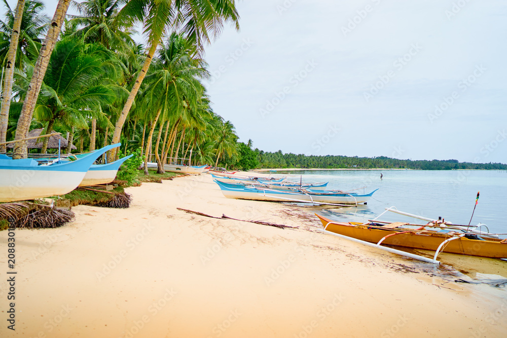 Beautiful landscape with tropical white sand beach with fishing boats. Siargao Island, Philippines.