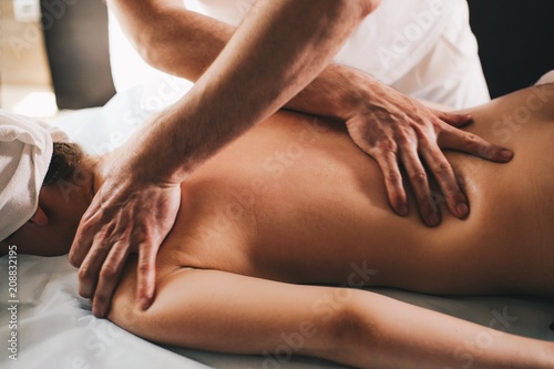 Male masseur doing girl massage in Spa salon close-up