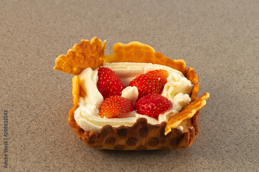 Homemade cookies of a square shape with white cream and strawberries on a marble surface. Homemade cookies of a square shape with white cream and strawberries on a marble surface.