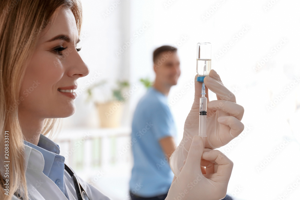 Doctor holding ampule with vaccine and syringe for patient in clinic Doctor holding ampule with vaccine and syringe for patient in clinic