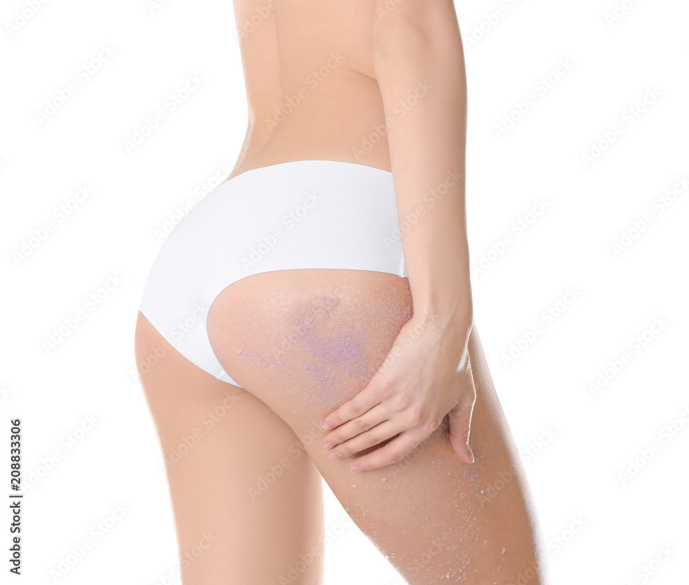 Young woman applying natural scrub on her body against white background