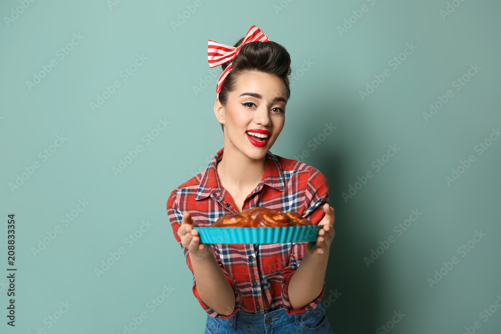 Funny young housewife with homemade pastry on color background Funny young housewife with homemade pastry on color background