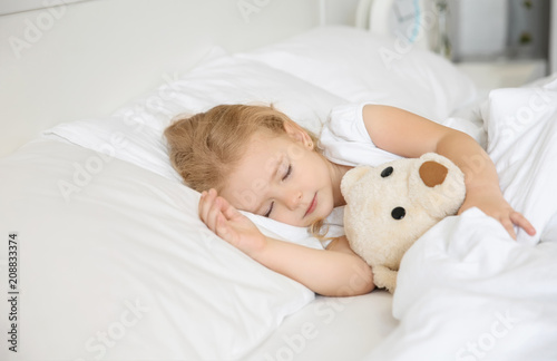 Cute little girl sleeping with toy in bed