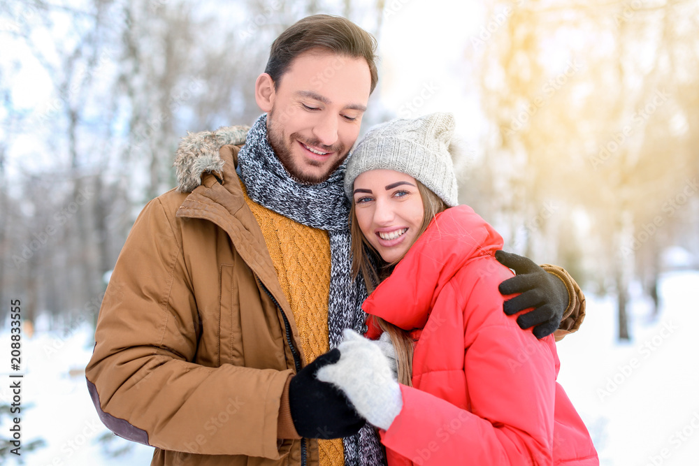 Obraz premium Young couple in snowy park on winter vacation