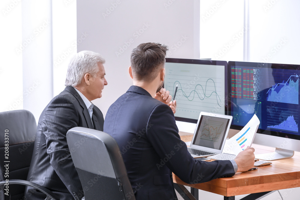 Male brokers working in office. Finance trading concept Male brokers working in office. Finance trading concept