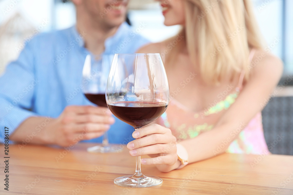Young romantic couple with glasses of red wine at table Young romantic couple with glasses of red wine at table