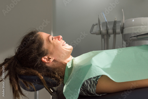 Female patient with dental braces on orthodontic chair photo