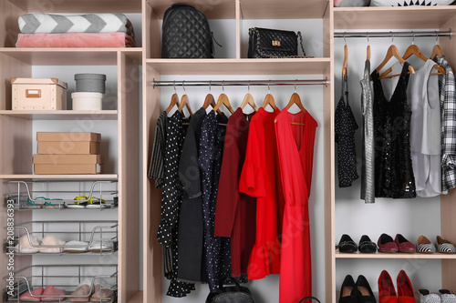 Large wardrobe with different clothes, home stuff and shoes photo