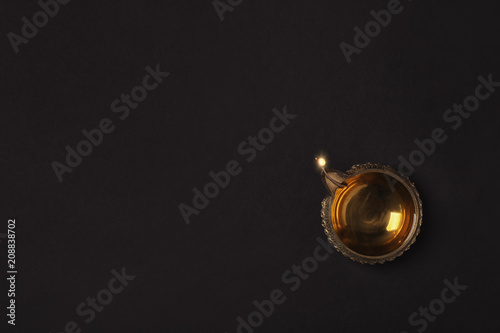 Diwali diya or clay lamp on dark background, top view