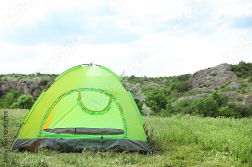 Small tourist tent in wilderness. Camping season