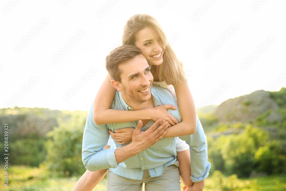 Cute young couple in love posing outdoors on sunny day Cute young couple in love posing outdoors on sunny day