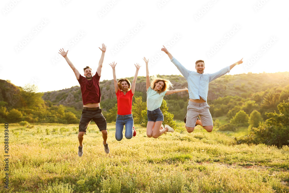 Happy young people jumping in wilderness. Camping season Happy young people jumping in wilderness. Camping season