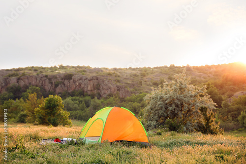 Small camping tent in wilderness on sunny day