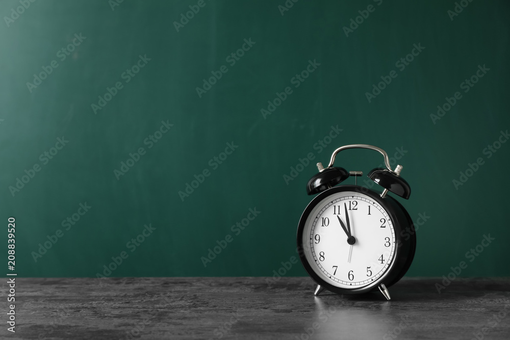 Alarm clock on table against color background. Time concept Alarm clock on table against color background. Time concept