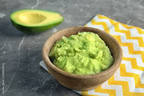 Bowl with guacamole made of ripe avocados on table
