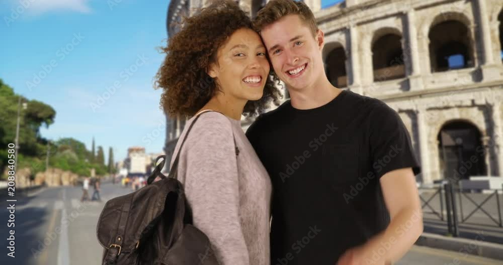 Cheerful couple in Rome smiling and waving at camera, Portrait of Caucasian male and female sightseeing near the Coliseum, 4k Cheerful couple in Rome smiling and waving at camera, Portrait of Caucasian male and female sightseeing near the Coliseum, 4k