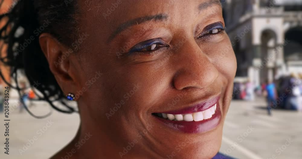 Close up of elderly black woman in St, Mark's square smiling into the distance, African American woman tourist enjoying trip in Venice, smiling and laughing, 4k