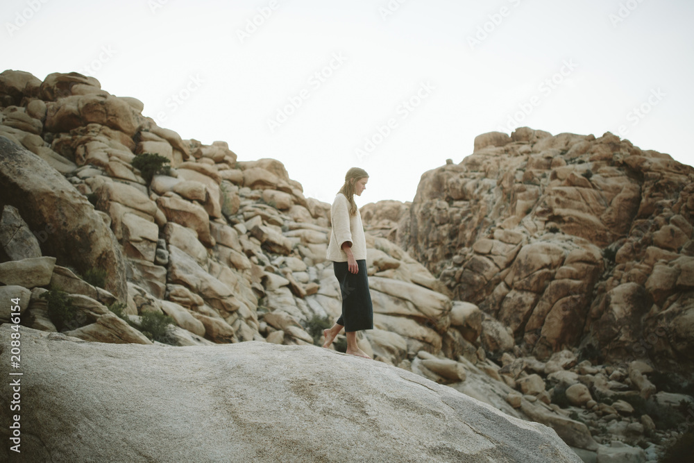 a young woman walks through the desert in Joshua Tree a young woman walks through the desert in Joshua Tree