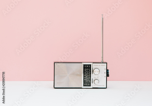 Vintage transistor radio in front of pink background photo