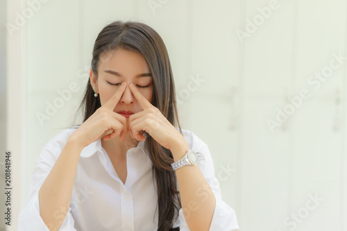 Stressed asian young business woman working with laptop and holding head with hands looking down. Negative human emotion facial expression feelings.