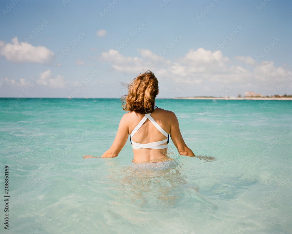 Beautiful woman in a bathing suit standing in an ocean Beautiful woman in a bathing suit standing in an ocean