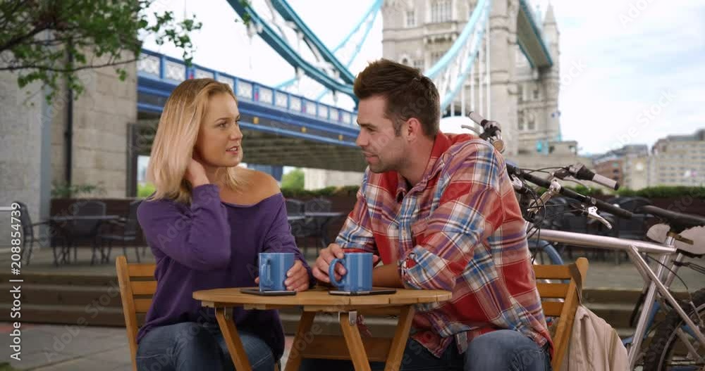 Couple chatting and drinking coffee by the Tower Bridge, A Caucasian man and woman having conversation and enjoying coffee in London, 4k Couple chatting and drinking coffee by the Tower Bridge, A Caucasian man and woman having conversation and enjoying coffee in London, 4k
