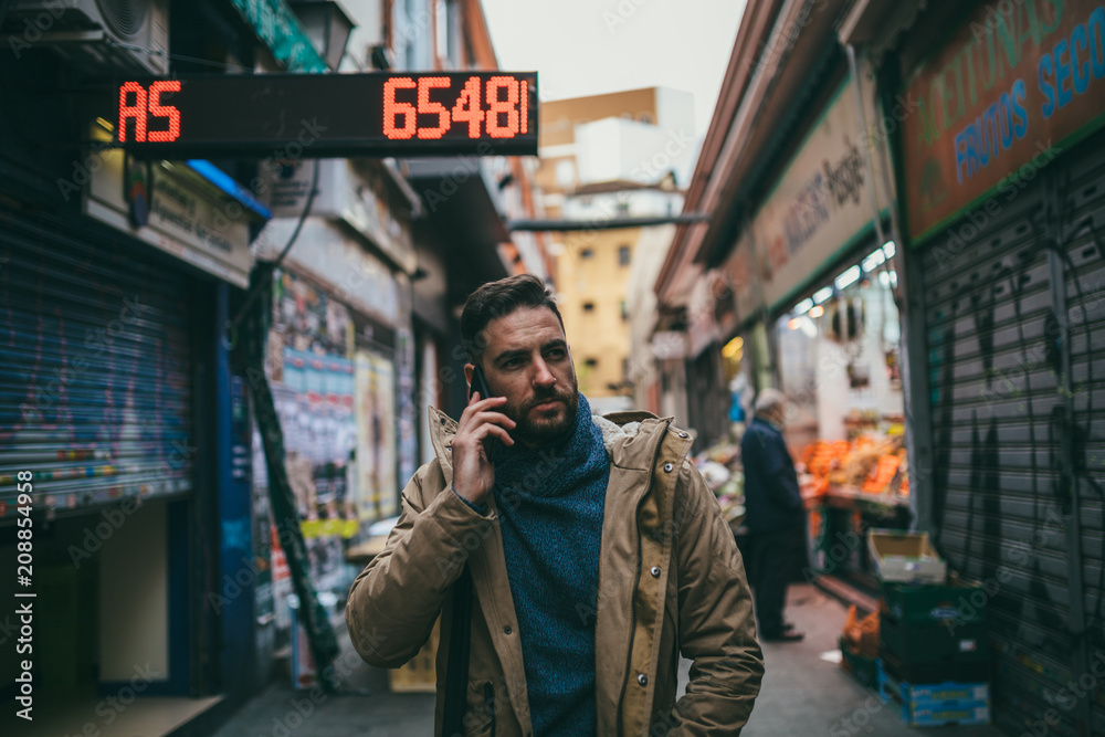 Handsome Bearded Man with Brown Coat talking on the phone Handsome Bearded Man with Brown Coat talking on the phone