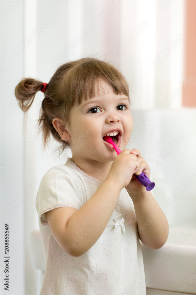 Cute toddler girl brushing teeth in bathroom Cute toddler girl brushing teeth in bathroom