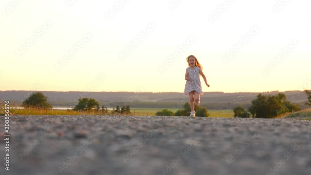 Little girl having fun run on the asphalt during the sunset in nature, lifestyle, outdoors. Little girl having fun run on the asphalt during the sunset in nature, lifestyle, outdoors.