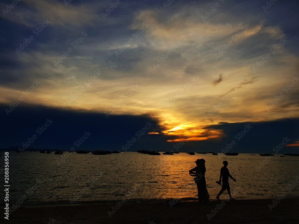 Pattaya, THAILAND - MAY 19, 2018: Silhouette of people having sunset beach in summer vacation as twilight times. Many tourists visit here. View for seascape. Travel concept. Space for text in template