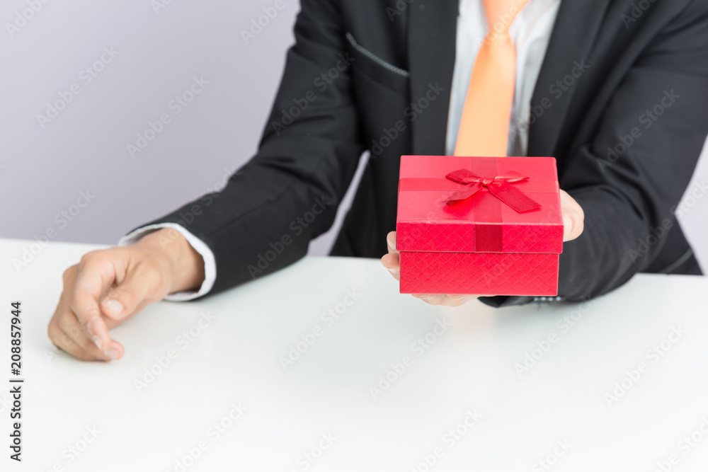 Businessman holds out the gift red box, isolated background Businessman holds out the gift red box, isolated background