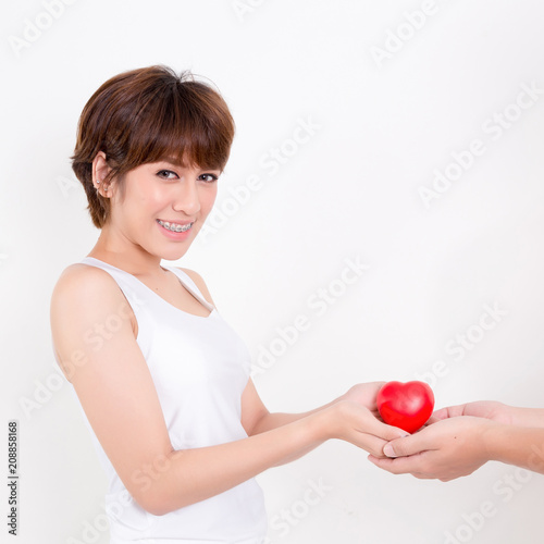 Man give the red heart to the young asia woman. Isolated on white background. Studio lighting. Concept for healthy.