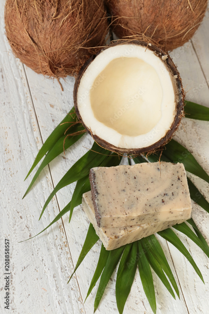 coconut soap.soap with coconut extract.  soap with coconut oil on a palm leaf and fresh coconut in a cut on a shabby wooden background.  Organic Natural  Cosmetics