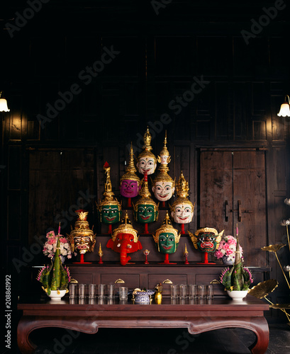 Collection of handmade  'Hua Khon' traditional mask for royal Thai performing arts in old wooden house photo