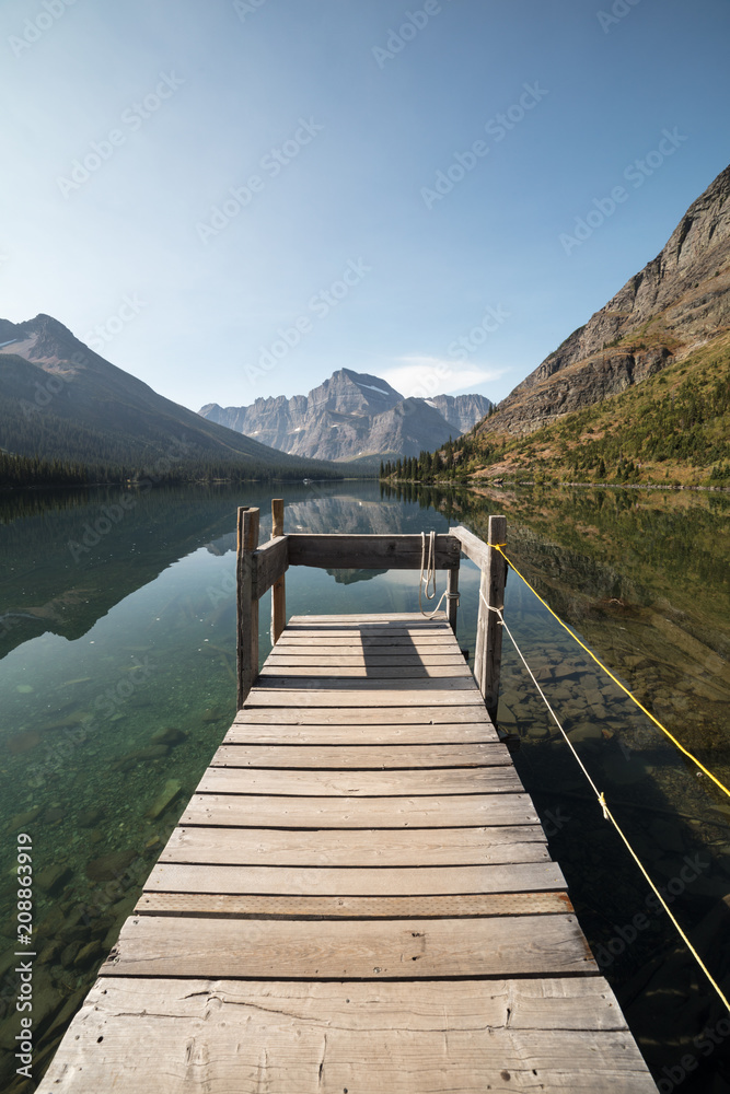 Pier and lake with mountain reflections on a sunny day