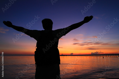 Silhouette of a man  in the beautiful sunrise. © YODCHAI