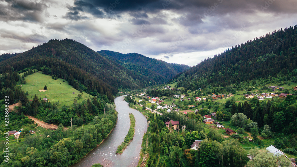 Aerial View:A picturesque village in the Carpathians, with a river and a spruce forest