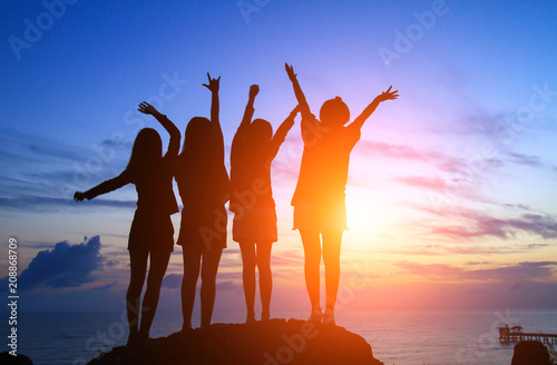 Silhouette of a happy woman and sunset in the seascape