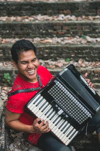 Asian man playing an accordion outdoor photo