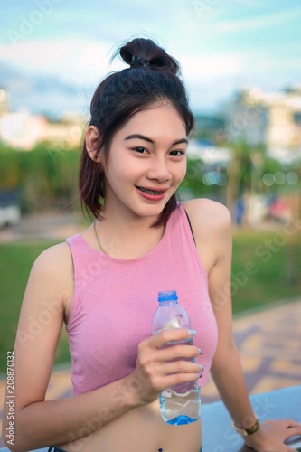 Asian woman showing a bottle of water