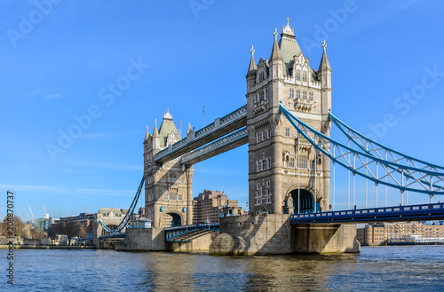 Tower Bridge against the winter blue sky. The bascule and suspension bridge crosses the River Thames and has become an iconic symbol of London.