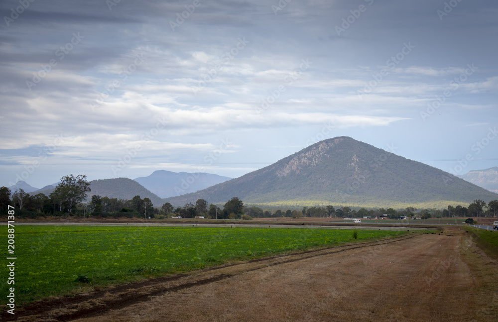 Fototapeta premium A cloudy winter sky over fields, farmlands adnd the mountains of the Great Dividing Range in Queensland, Australia