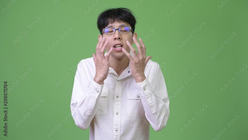 Young Asian businessman shocked while covering mouth Young Asian businessman shocked while covering mouth