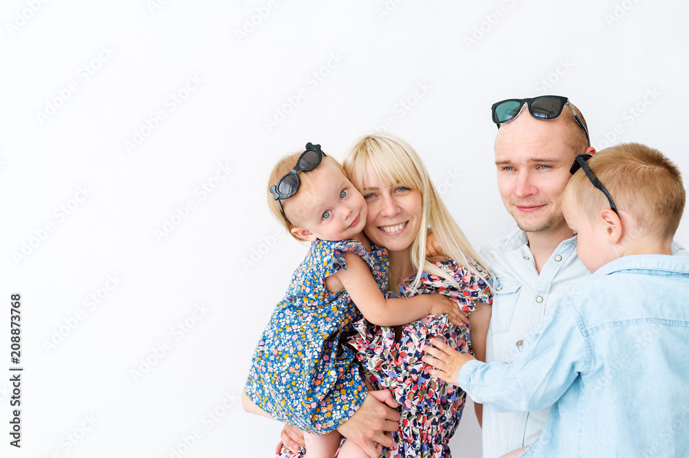 Father, mother and two small children are standing together on the white background. Father, mother and two small children are standing together on the white background.