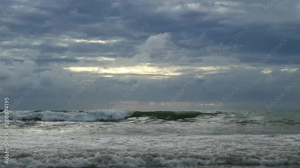 sandy beach with waves at sunset, thunderclouds on a sky. dramatic atmosphere sandy beach with waves at sunset, thunderclouds on a sky. dramatic atmosphere