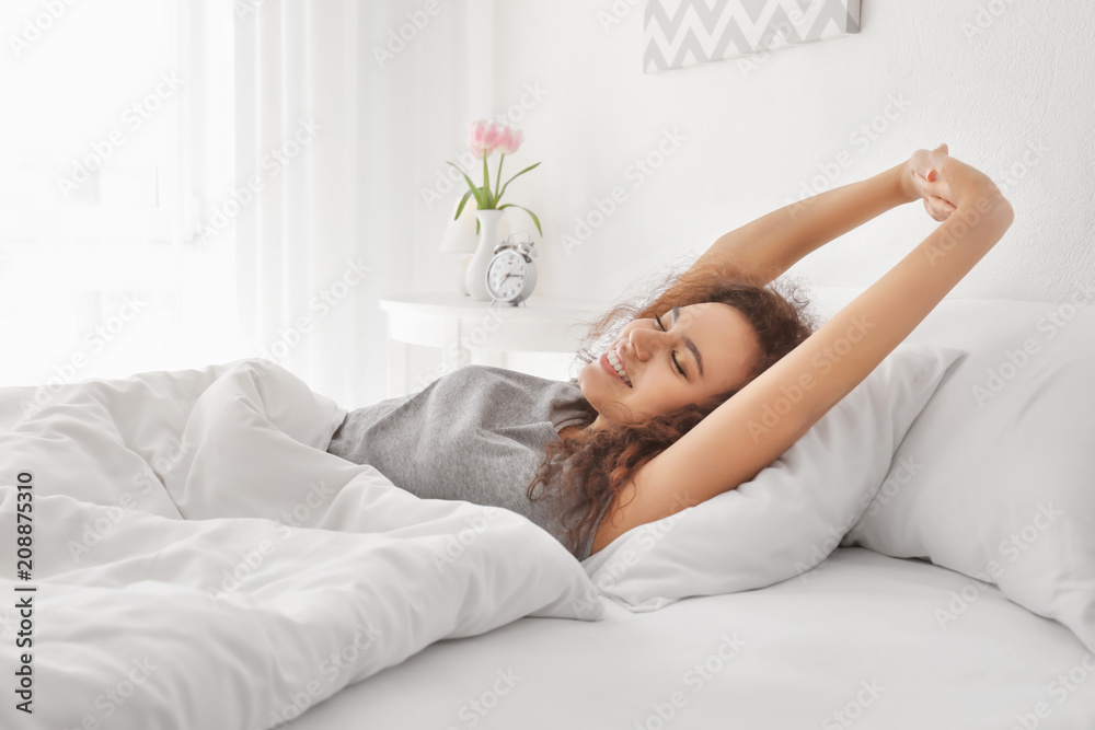 Morning of young African-American woman in bed - obrazy, fototapety, plakaty 